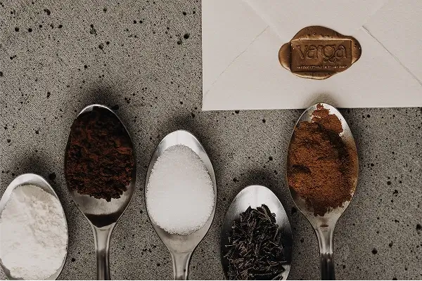 Linguri cu făină, cacao, zahăr și condimente folosite pentru turta dulce Varga Mézes, lângă un plic cu sigiliu de ceară